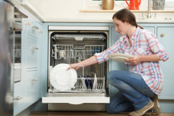 woman loading the dishwasher in the kitchen